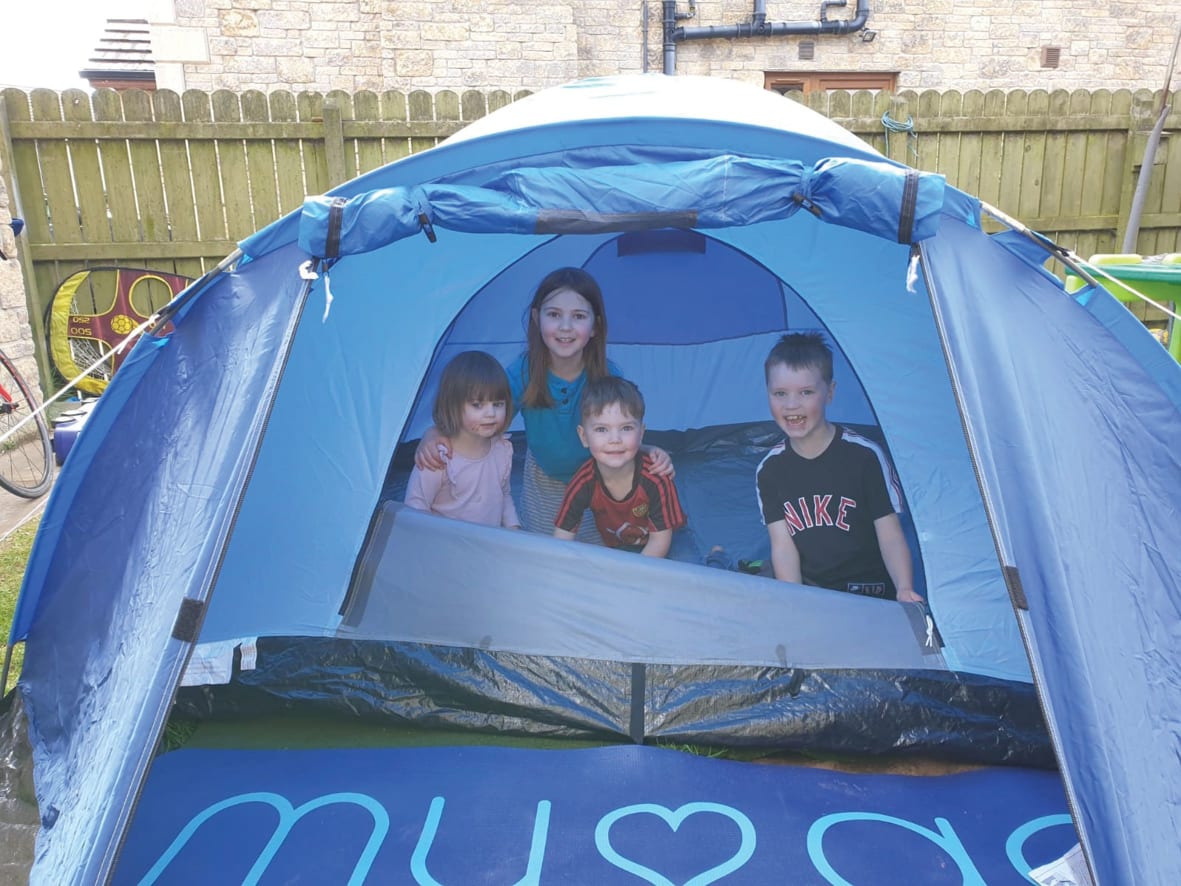 A family in a blue tent