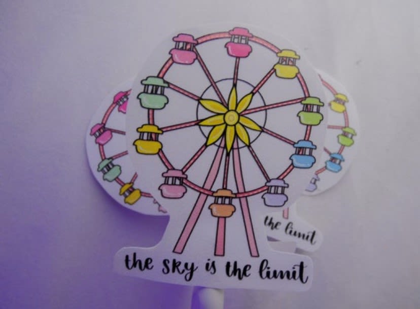 a ferris wheel sticker with "The skys the limit" written underneath on a white background